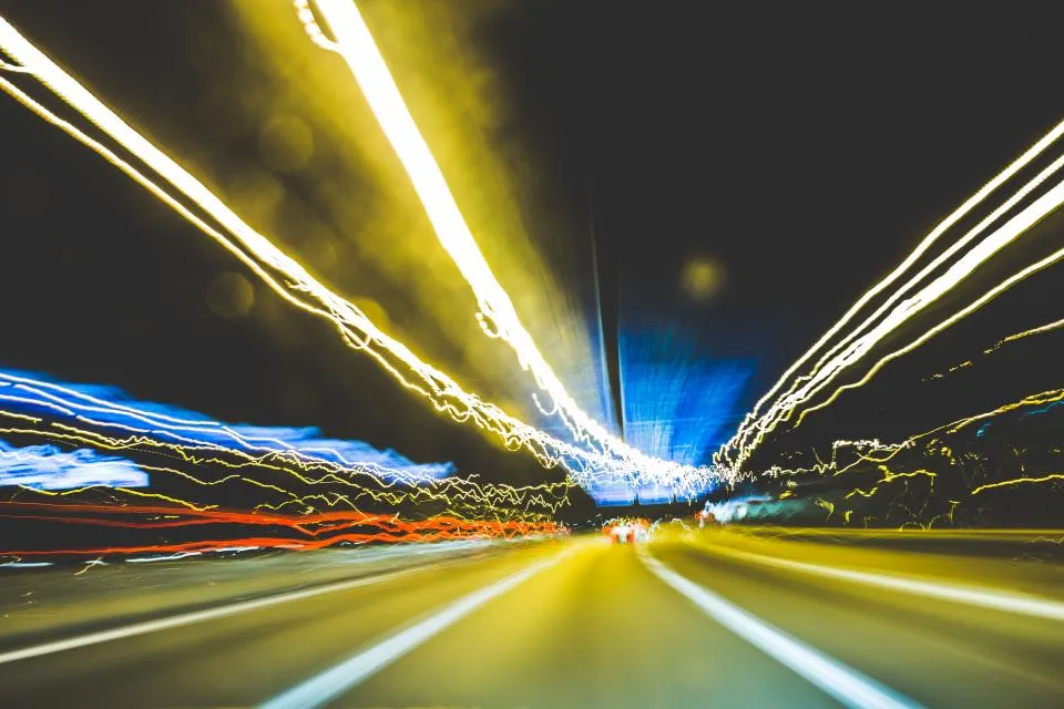 Long-exposure light trails along a city road at night